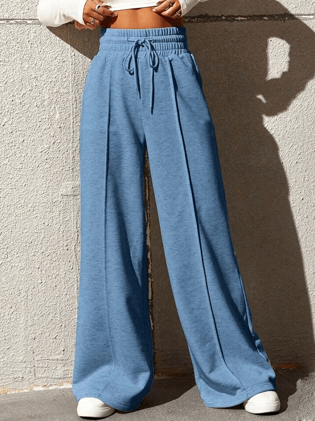 Women's blue drawstring pleated wide leg pants with high waist, featuring a chic and comfortable fit against a neutral background.